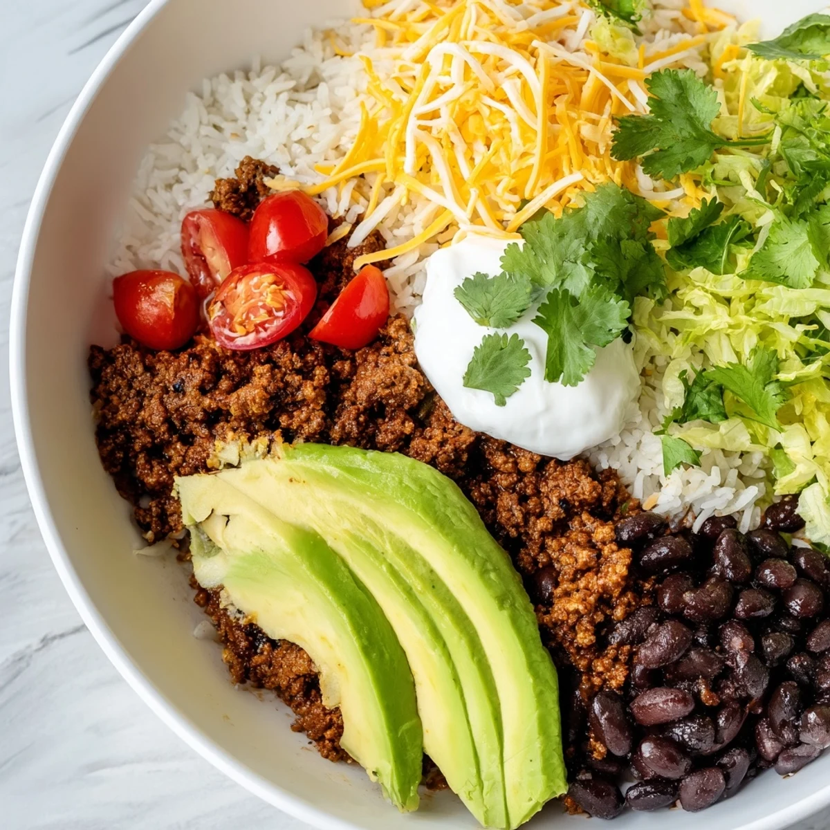 A steaming Beef Burrito Bowl topped with shredded cheese, avocado slices, and cilantro, ready for a family dinner.