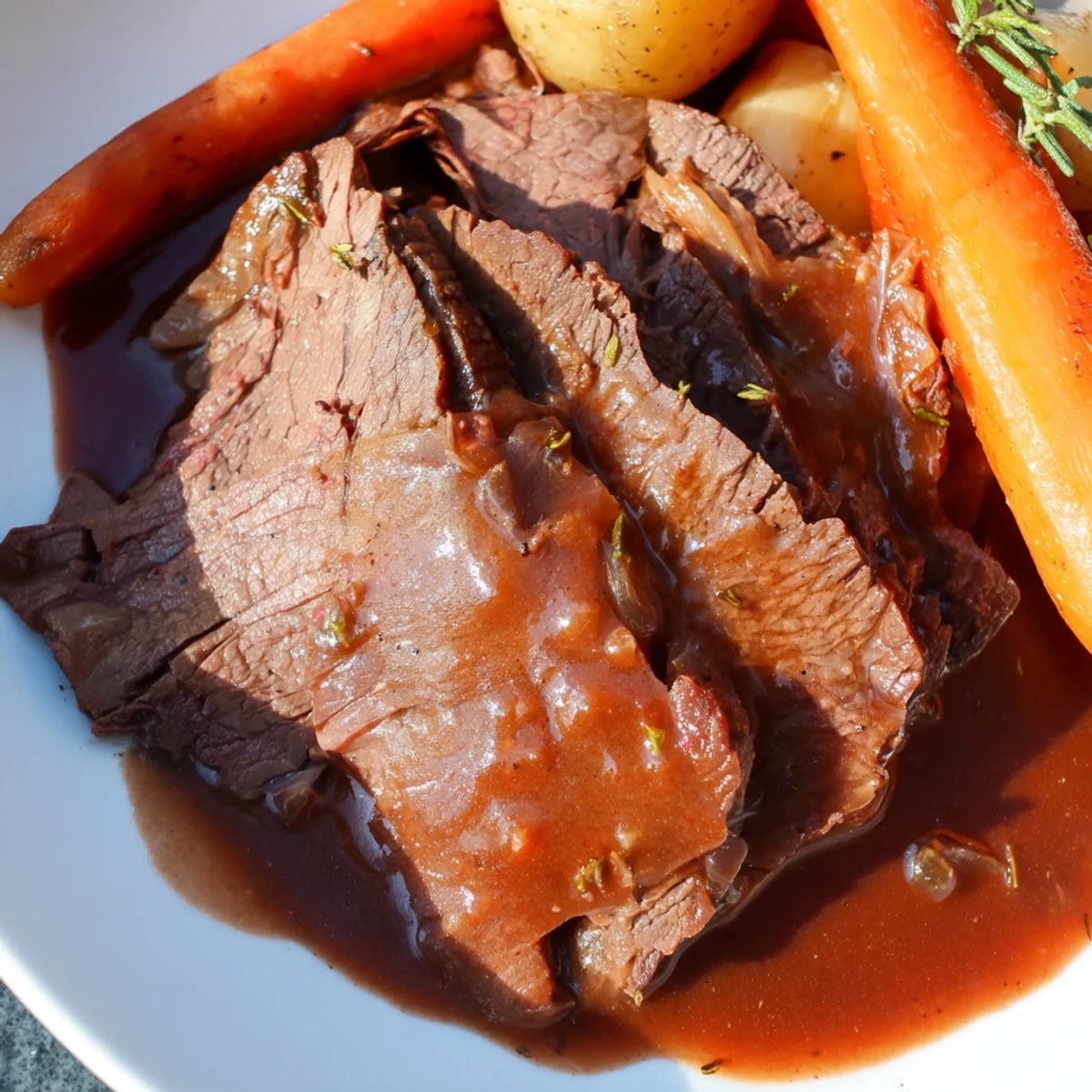 Slow Cooker Pot Roast with Savory Gravy steaming on a platter with tender carrots, potatoes, and onions.