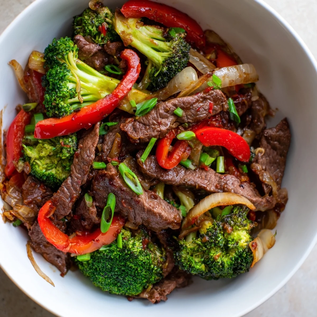 Tender strips of flank steak and crisp broccoli florets are tossed in a spicy garlic sauce, creating a perfect quick weeknight dinner for four.