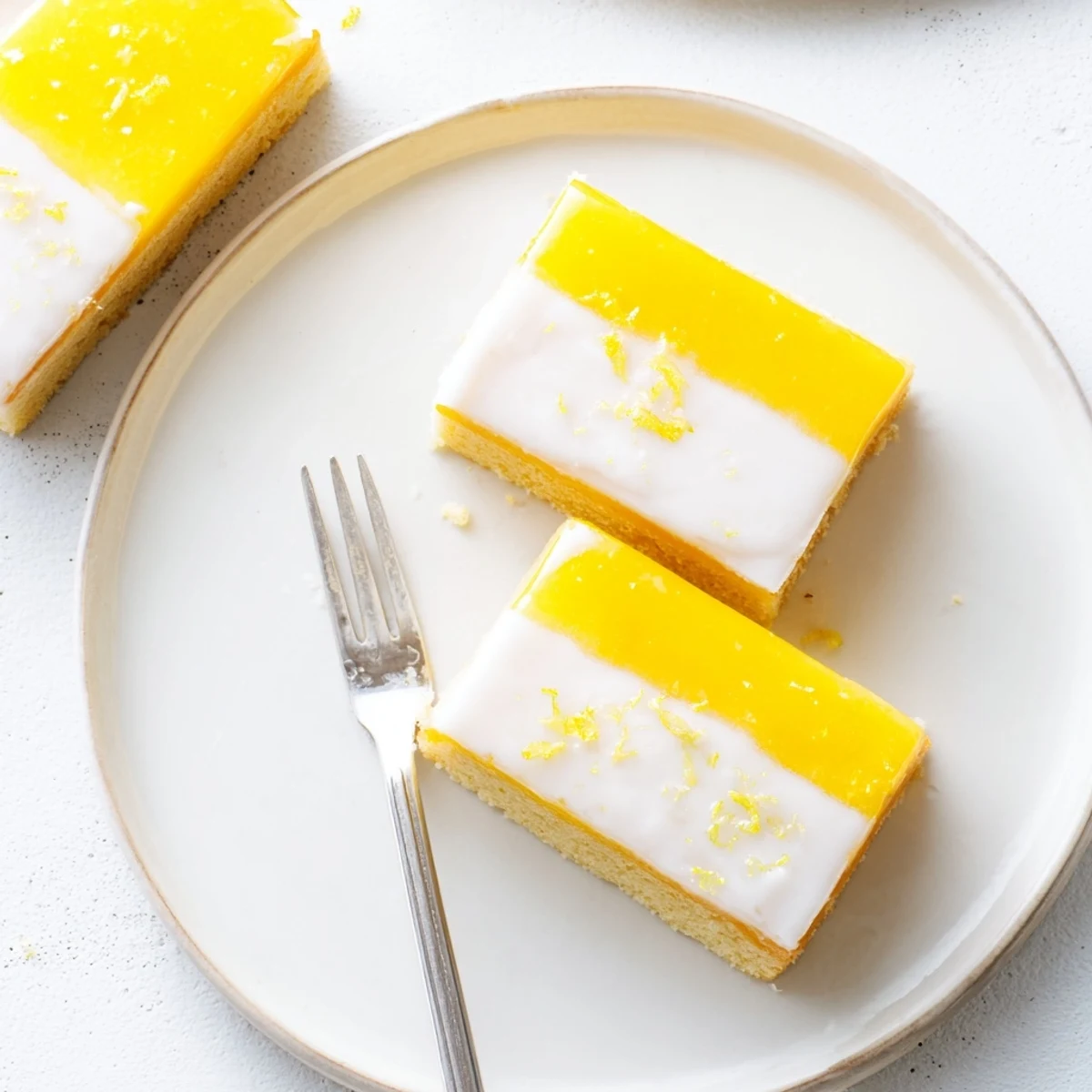 A close-up slice of Lemon Dessert Bar showcases the bright yellow filling, powdered sugar glaze, and crumbly crust for a refreshing dessert.  