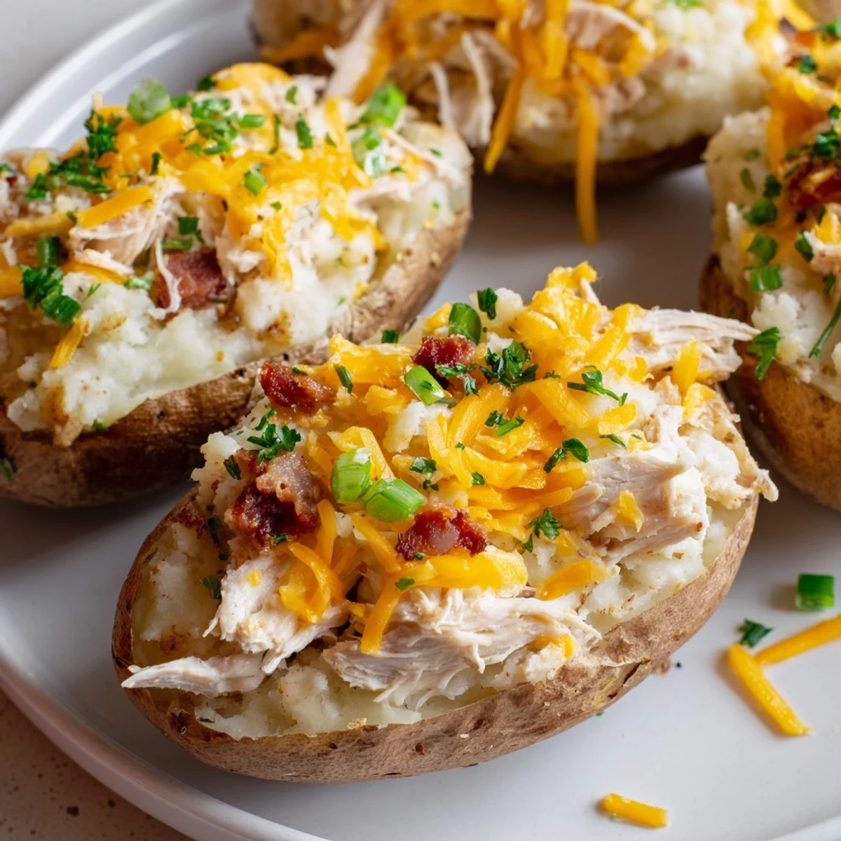 Four large russet potatoes are twice-baked with a creamy chicken filling, topped with melted cheddar and fresh parsley.