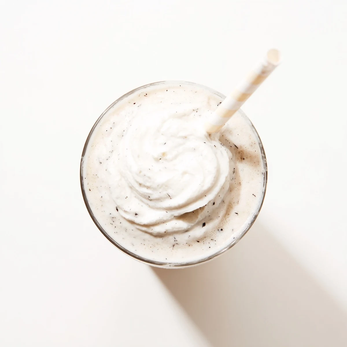 The frosty Vanilla Bean Frappuccino shows ice crystals and a straw on top.