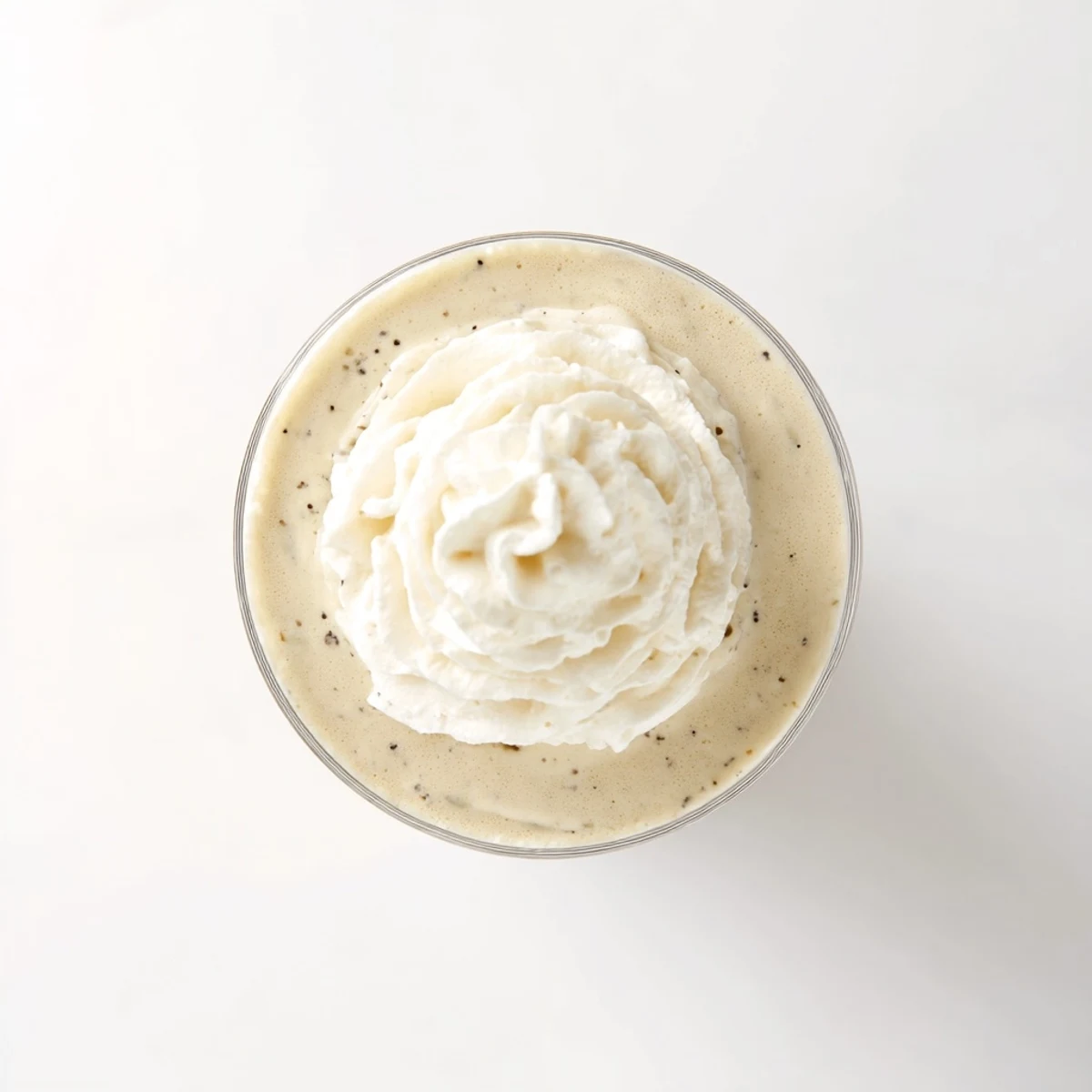 Homemade Starbucks Vanilla Bean Frappuccino poured into a glass with a straw, a refreshing summer beverage.