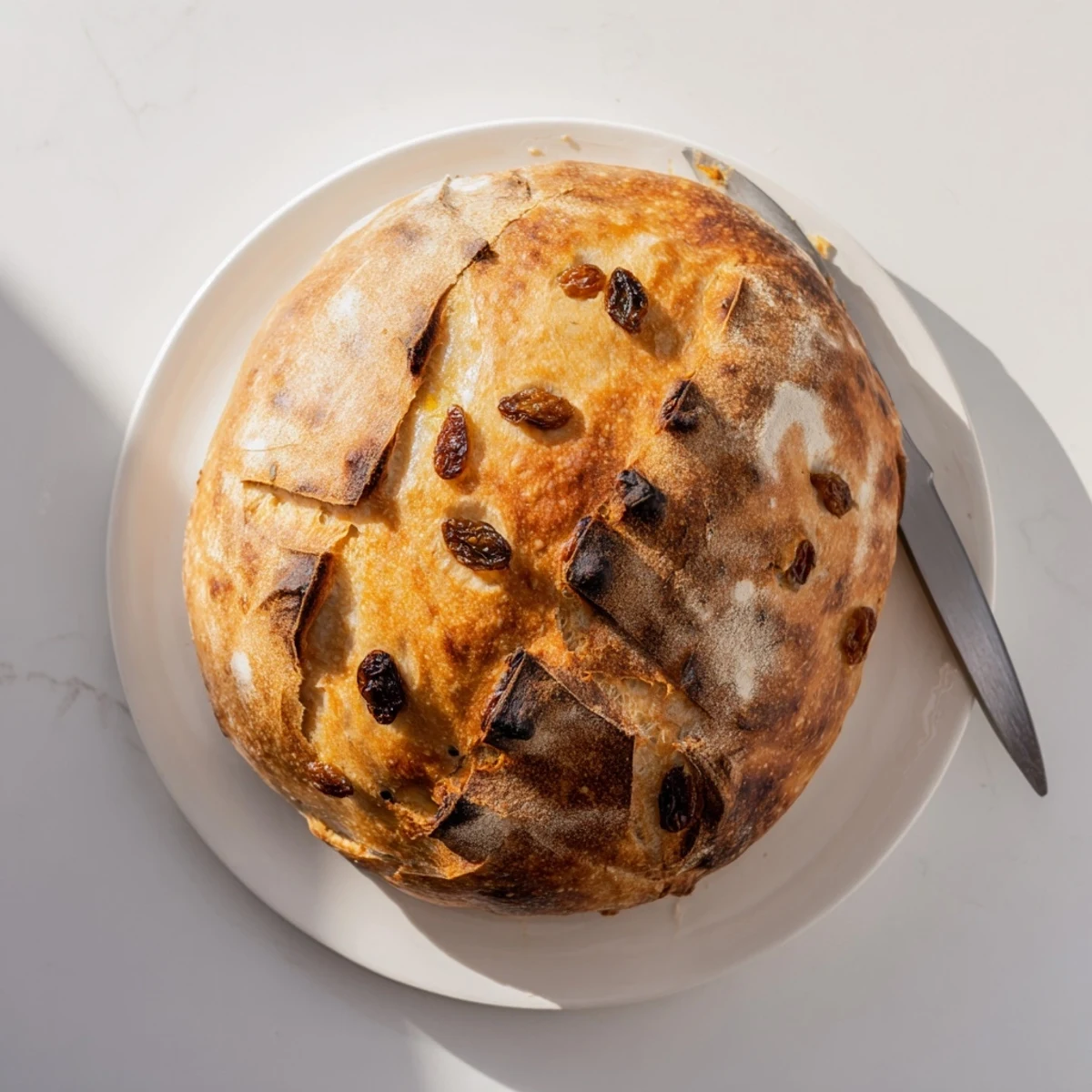 Rustic golden-brown Cinnamon Raisin Artisan Bread resting on a wire rack, its aromatic cinnamon scent filling a cozy American kitchen.