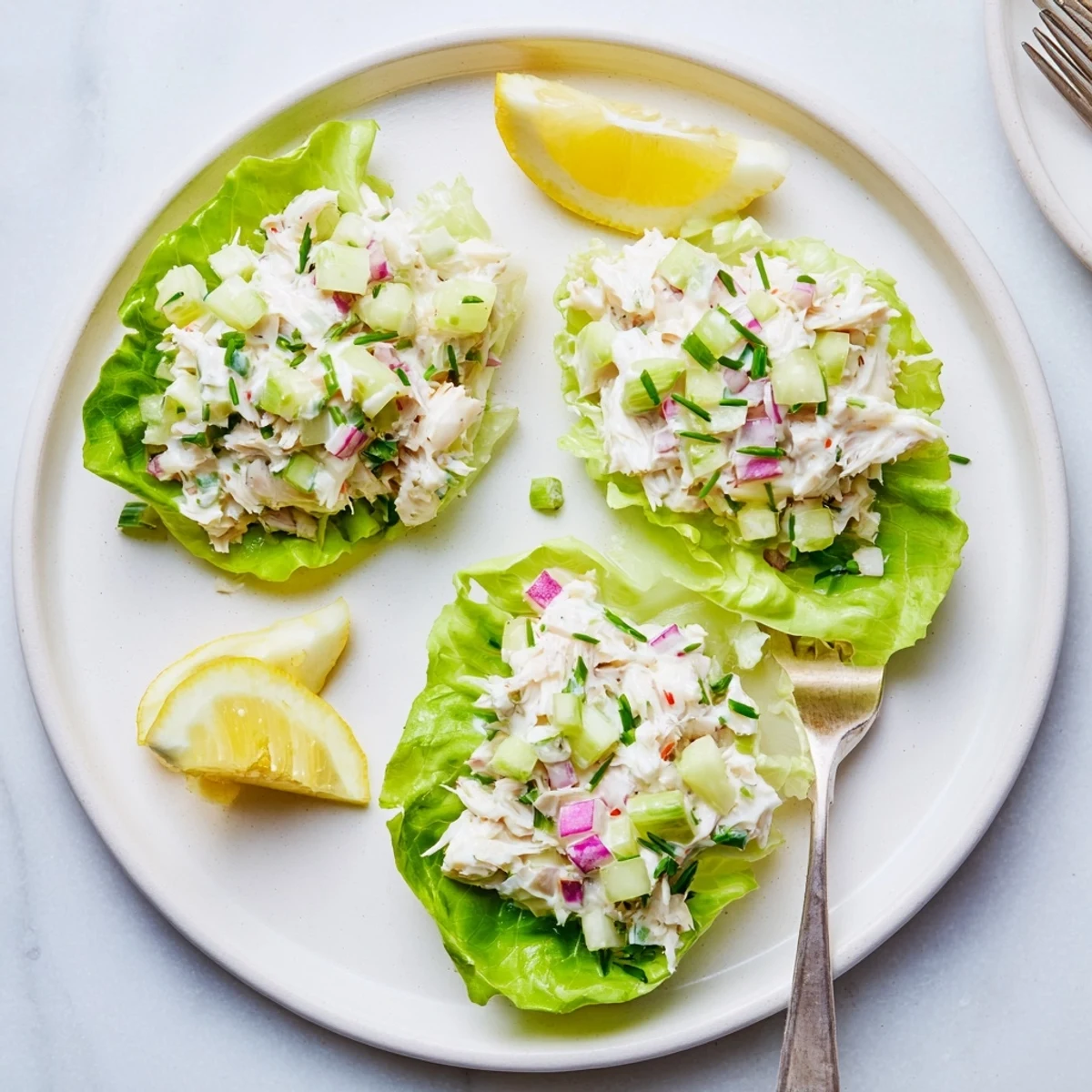 Chilled crab salad served on butter lettuce, garnished with fresh chives for a refreshing light lunch.
