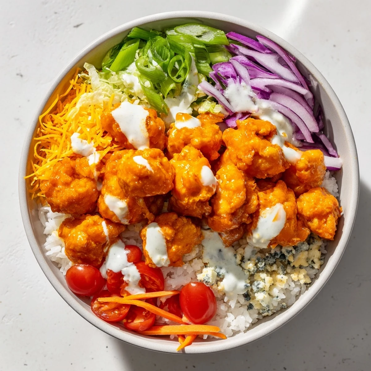 Vibrant Buffalo Chicken Bowls feature spicy shredded chicken, fluffy rice, crisp romaine, and creamy ranch drizzle.