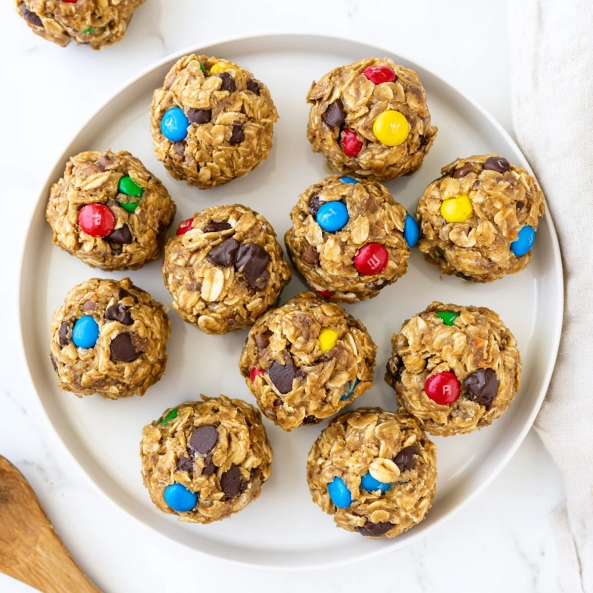 A generous bowl of Monster Cookie Protein Balls is ready to serve, with bright M&Ms peeking out from a wholesome snack.