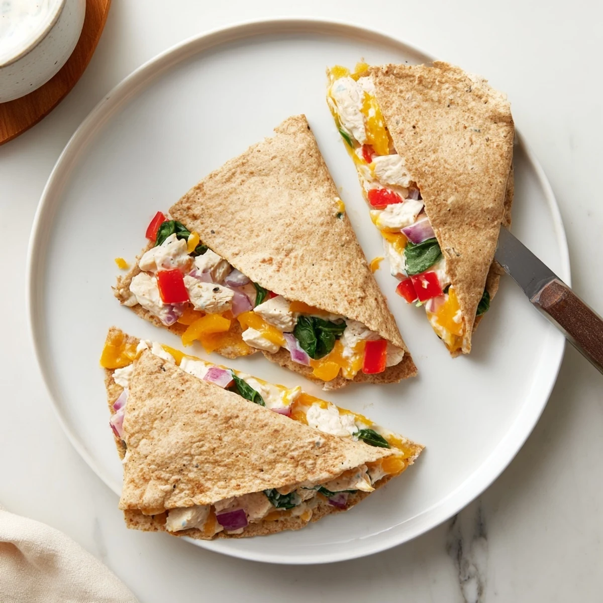Golden brown high protein chicken ranch quesadilla sliced into wedges revealing melted cheese and colorful vegetables