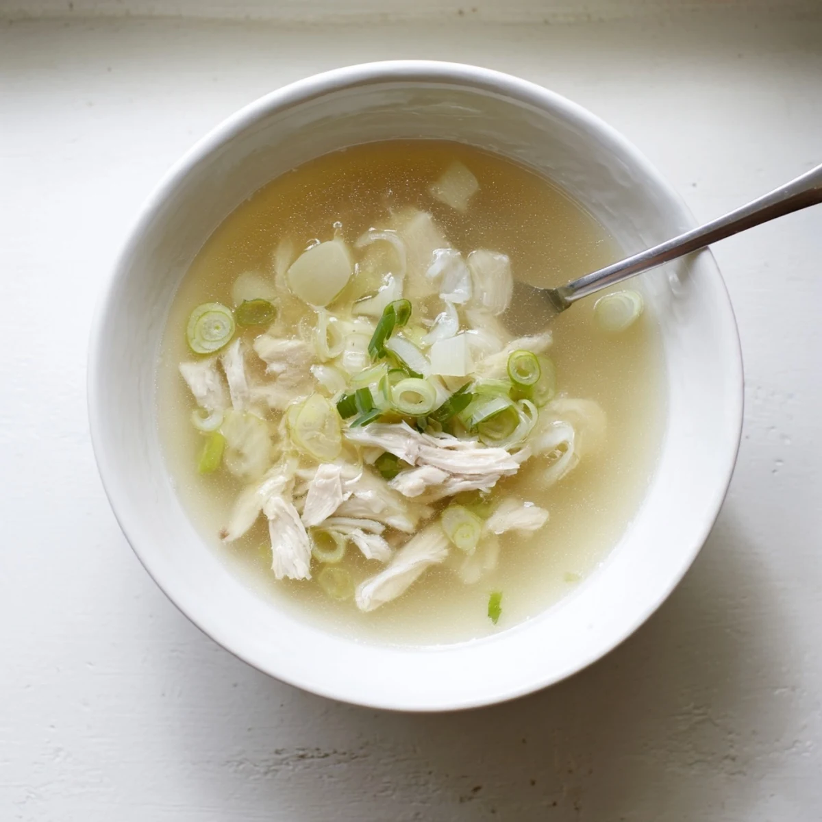 Steaming bowl of Dakgomtang Korean chicken soup garnished with fresh green onions and served hot
