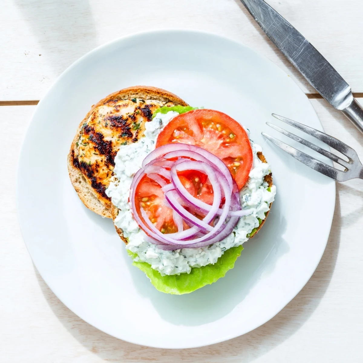 Juicy Greek chicken burgers with homemade tzatziki, crisp lettuce, and ripe tomato slices