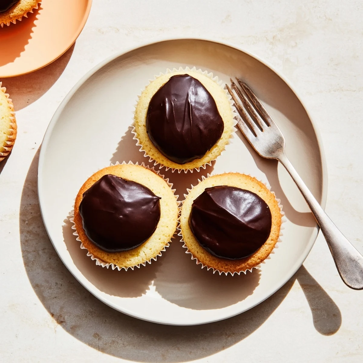 Golden vanilla cupcakes filled with creamy pastry cream topped with glossy chocolate ganache Boston cream pie cupcakes