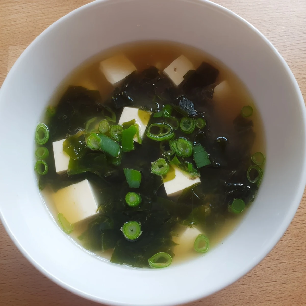 Japanese easy authentic miso soup featuring silken tofu and rehydrated wakame seaweed in golden dashi broth