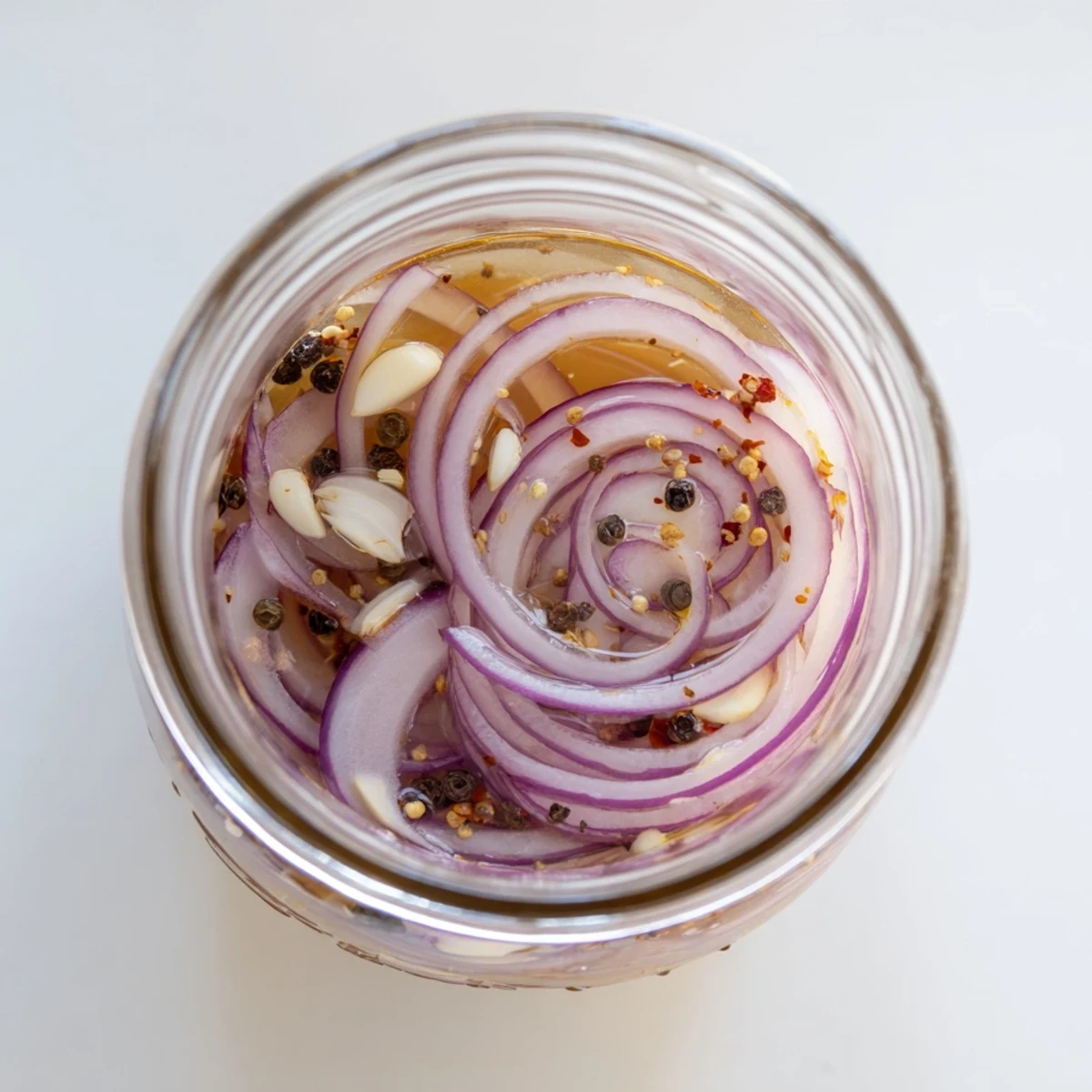 Glass jar filled with sweet and spicy pickled red onions ready for tacos and burgers