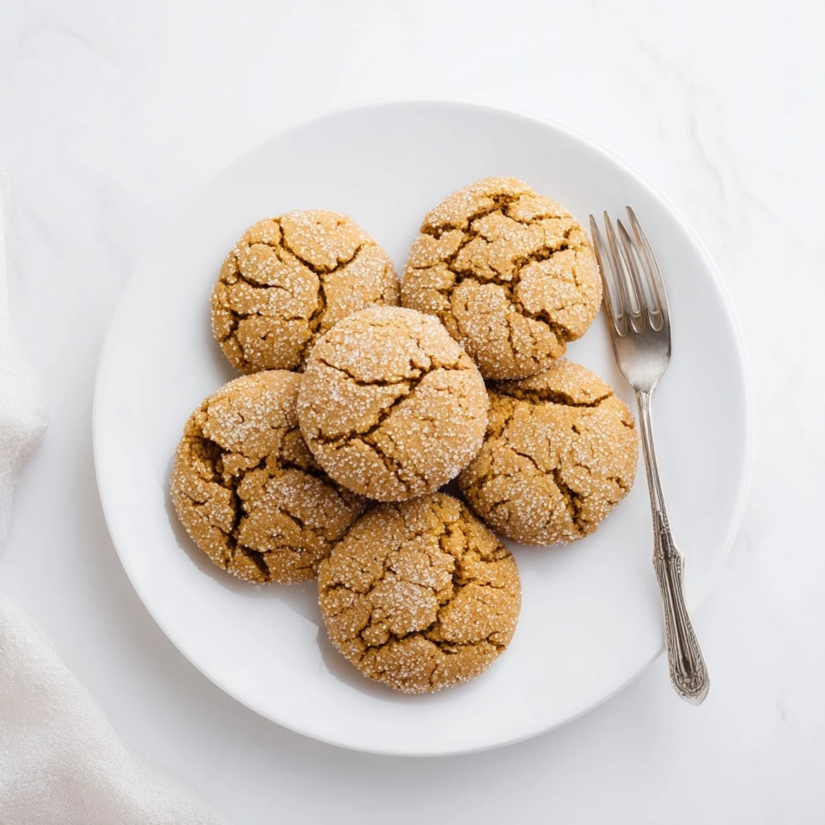 Plate of homemade gingersnap cookies dusted with sugar, ready for holiday serving