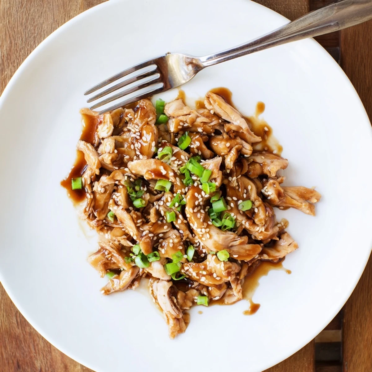 Tender shredded Crockpot Teriyaki Chicken coated in glossy sweet and savory sauce.
