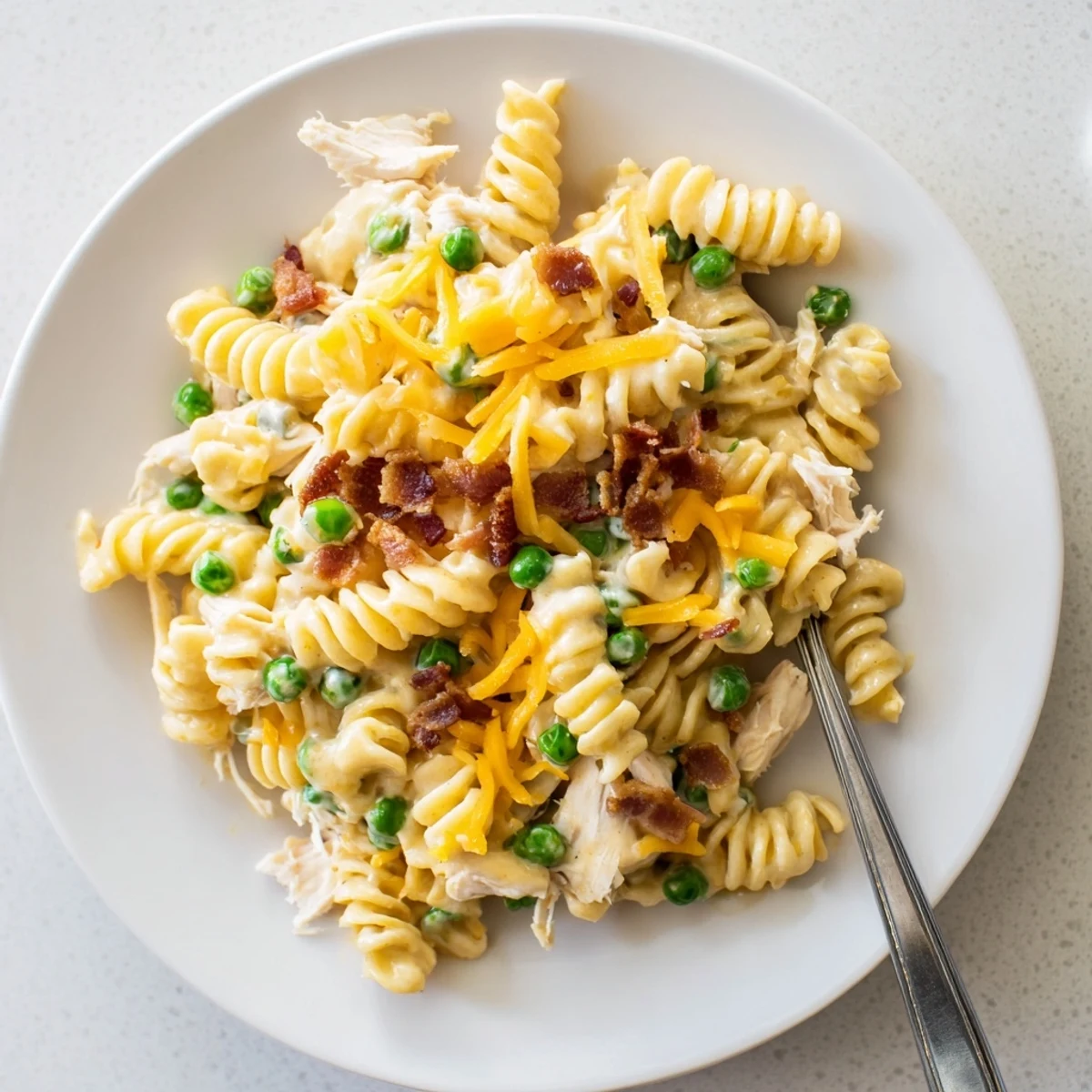 Golden Crock Pot Crack Chicken Casserole with melted cheddar and crispy bacon bits topping