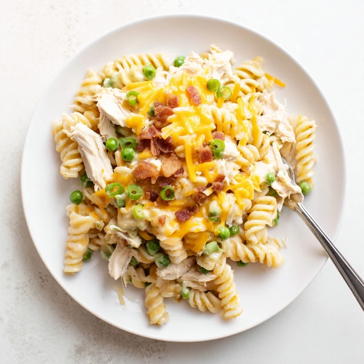 Serving bowl of Crock Pot Crack Chicken Casserole garnished with green onions and extra bacon