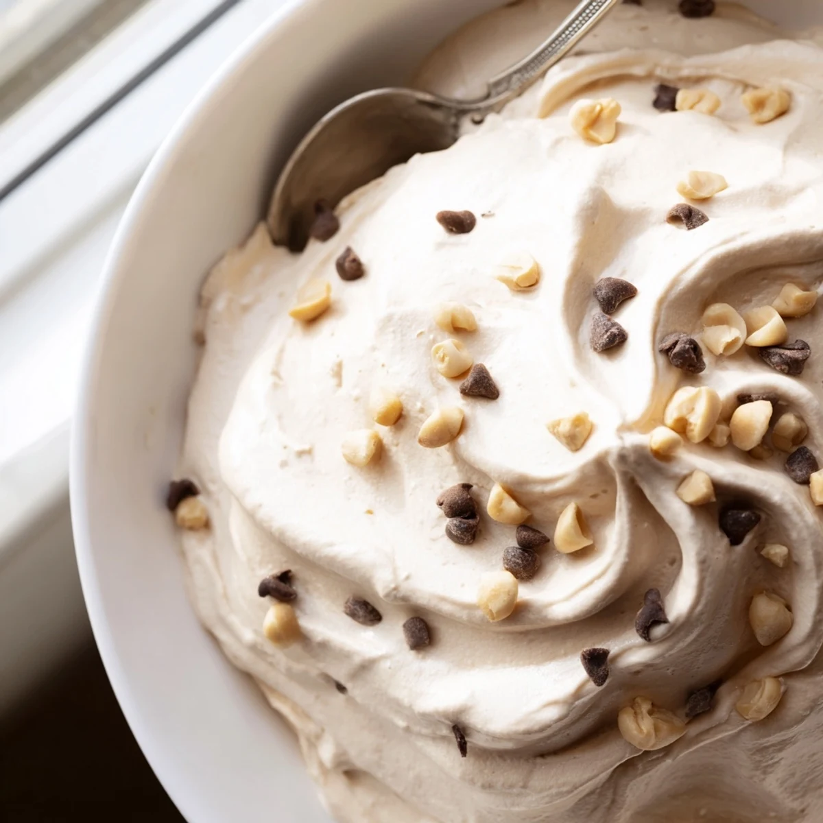 Creamy peanut butter and Cool Whip mousse served in clear glasses with chocolate chip garnish