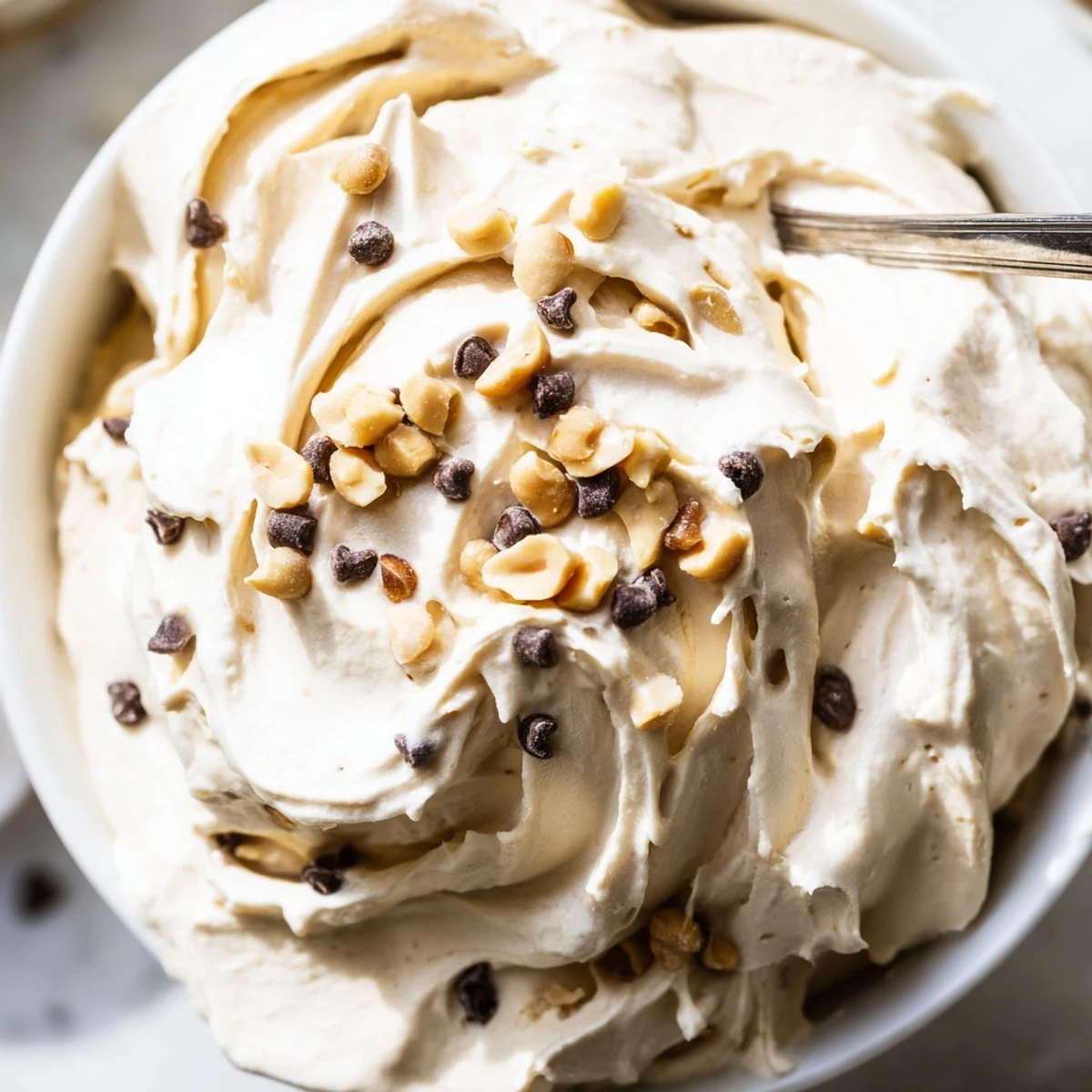 Light peanut butter and Cool Whip mousse layered in serving dishes with chocolate drizzle