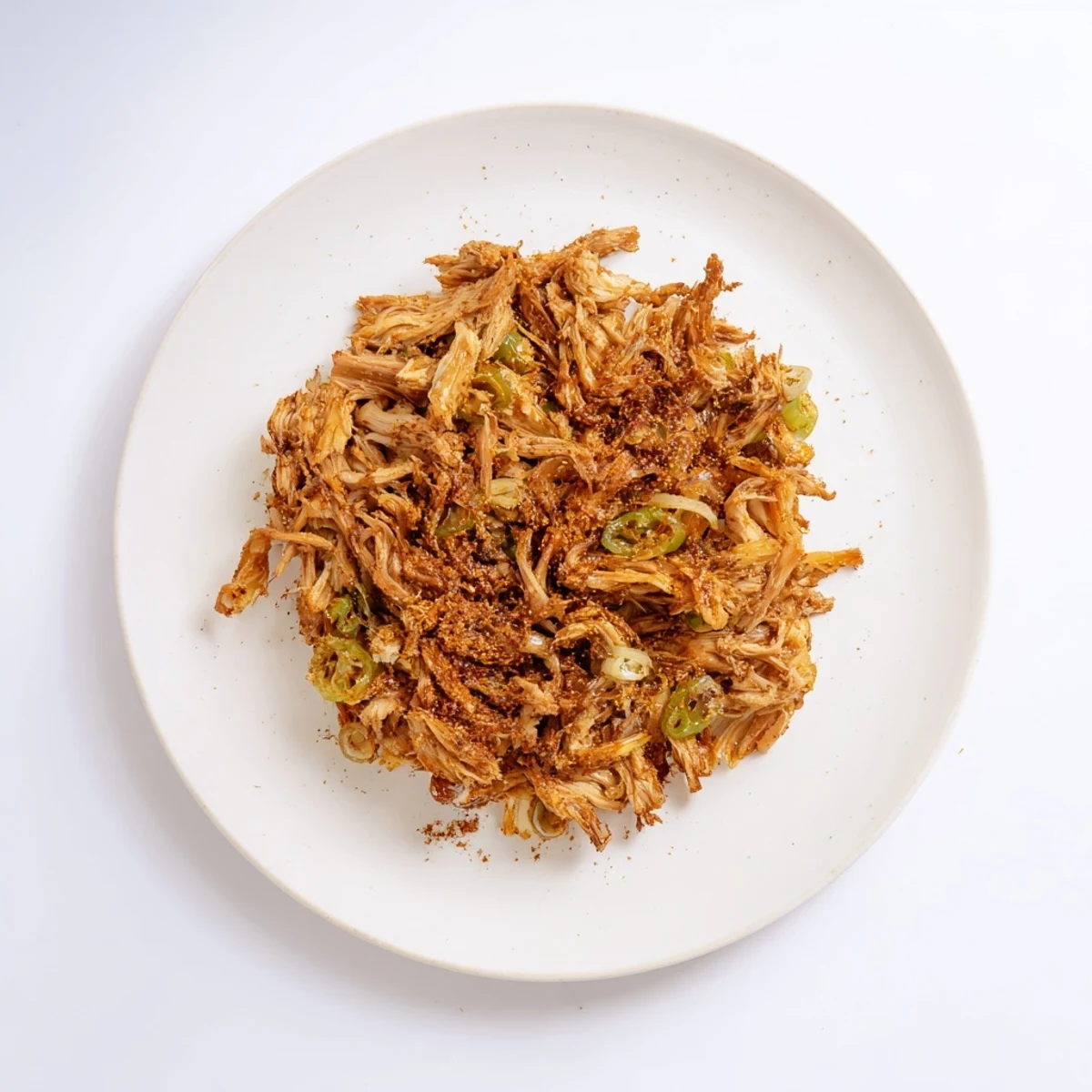 Golden brown shredded vegan carnitas with mushrooms piled on warm corn tortillas