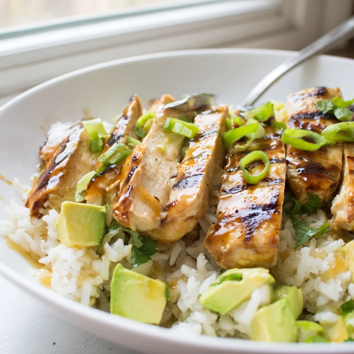 Juicy honey lime chicken with grill marks served alongside creamy avocado rice