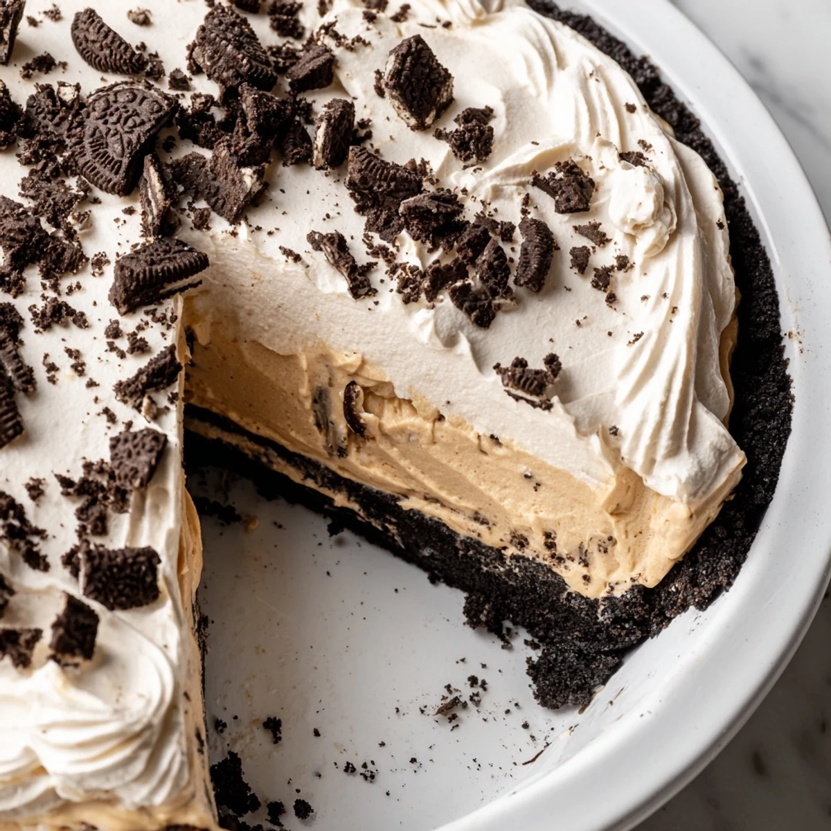 Silky peanut butter Oreo pie sliced to reveal layers of creamy filling and crust