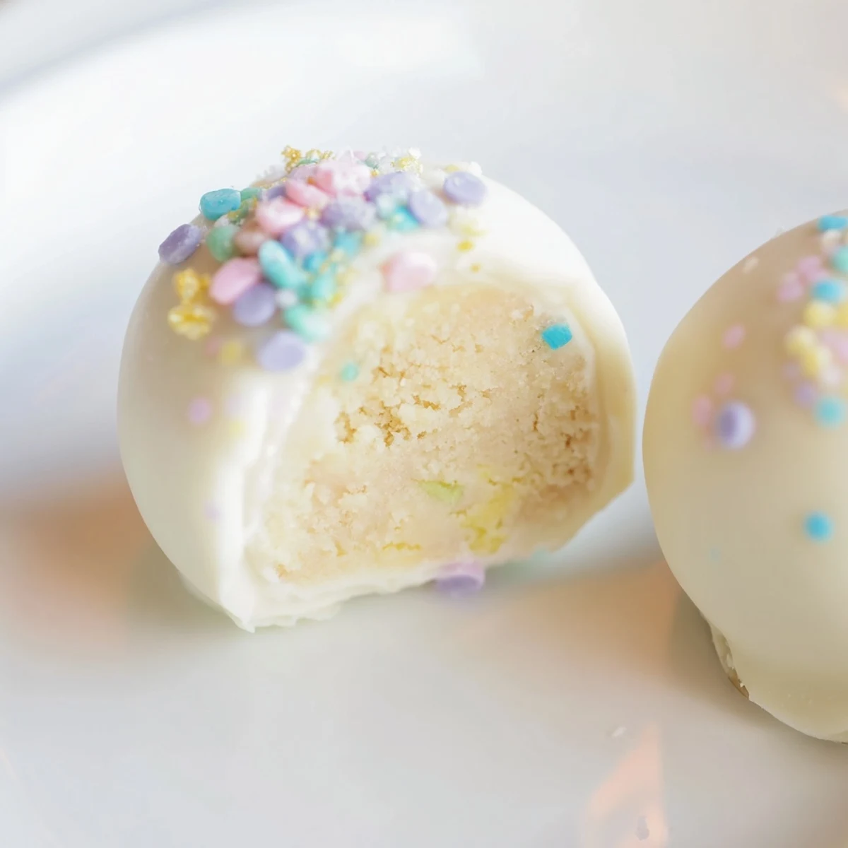 Creamy Banana Pudding Easter Truffles coated in white chocolate with colorful festive sprinkles