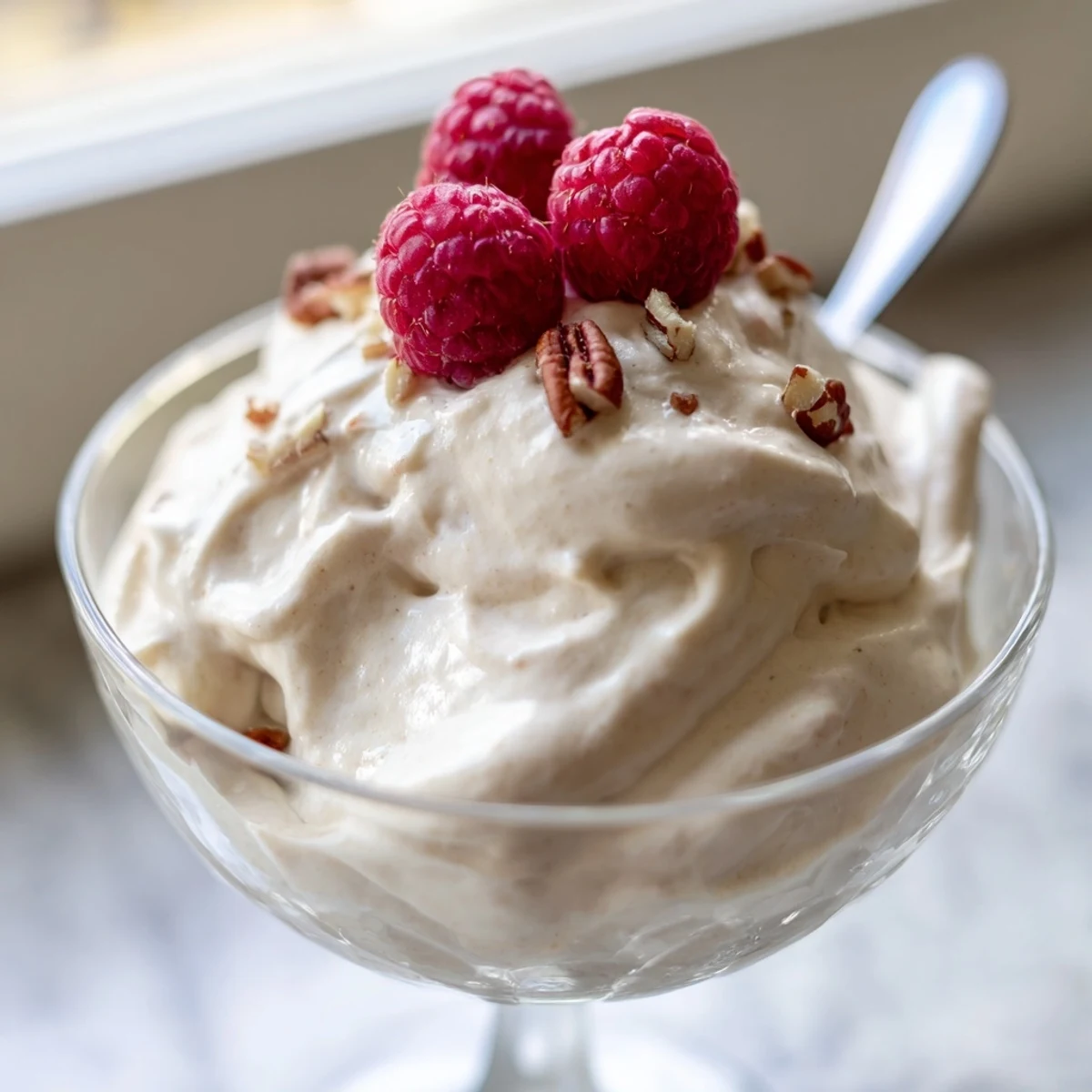 Fluffy keto cheesecake fluff swirled with vanilla and served with chopped pecans