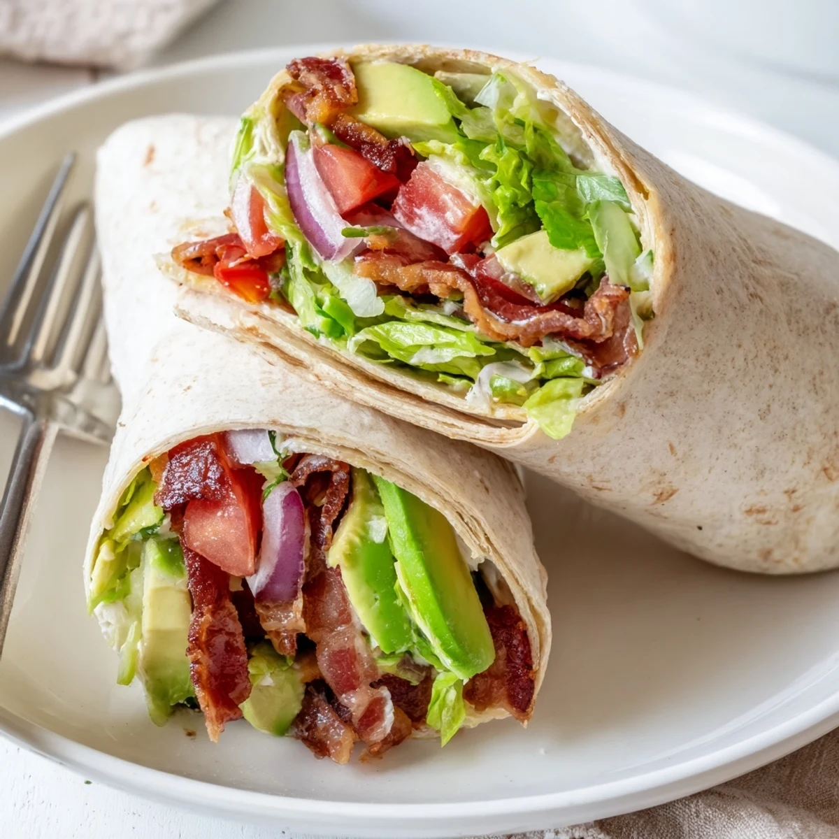 Chilled Meal Prep BLT Wraps sliced in half, creamy dressing visible