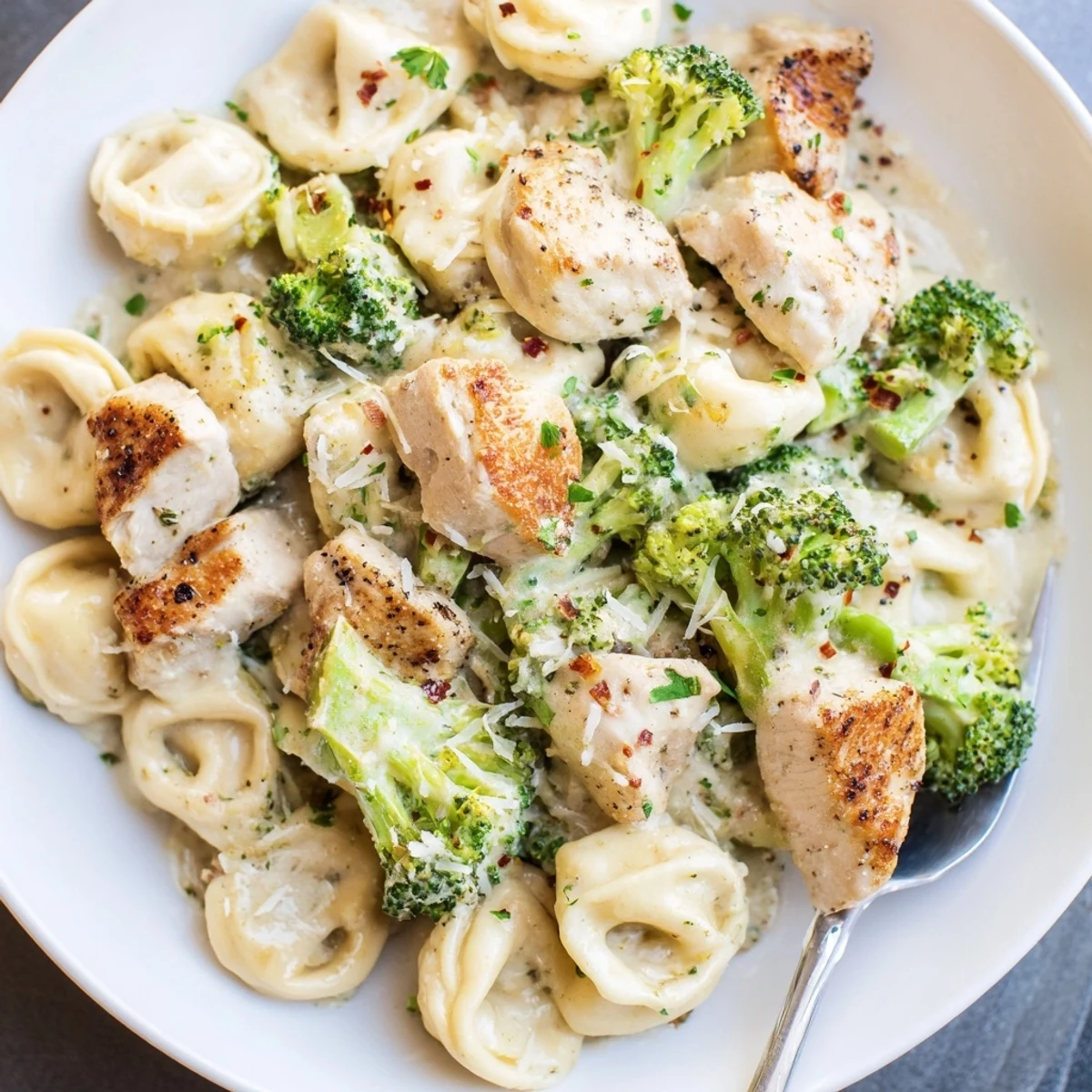 Creamy Garlic Parmesan Tortellini Chicken Broccoli Recipe served from skillet, steaming, silky Parmesan