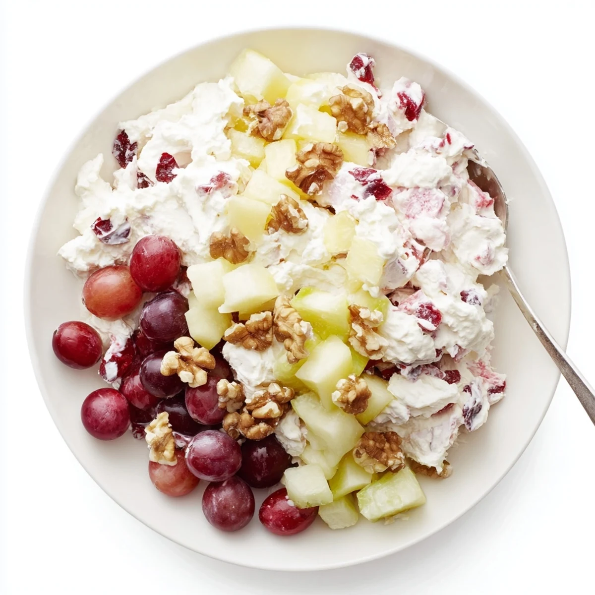Frozen cranberry salad with red berries and creamy white mixture in a glass serving dish