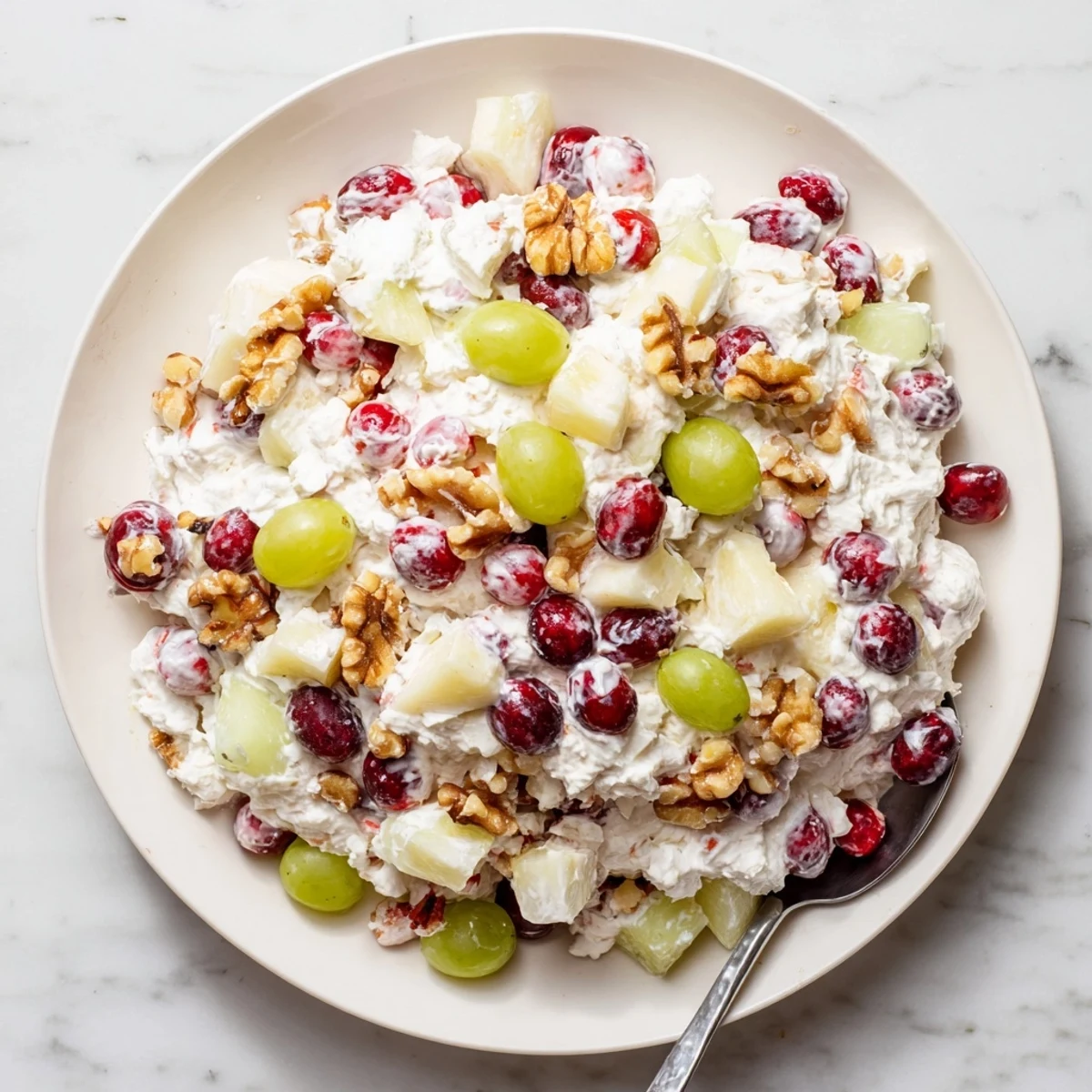 Sliced frozen cranberry salad showing colorful fruit pieces and walnuts throughout the white creamy base