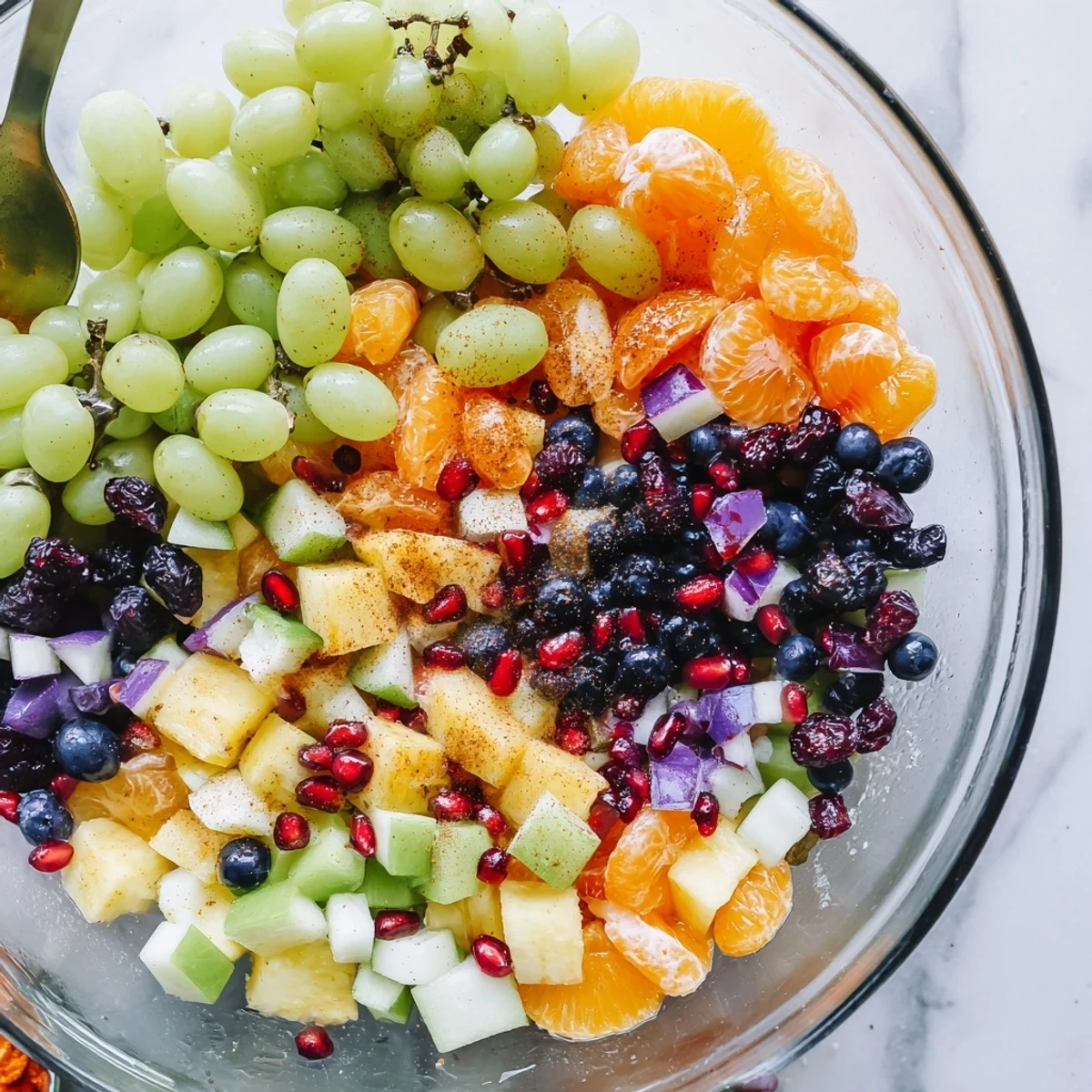 Fresh Halloween fruit salad with honey orange dressing featuring purple grapes and green apples