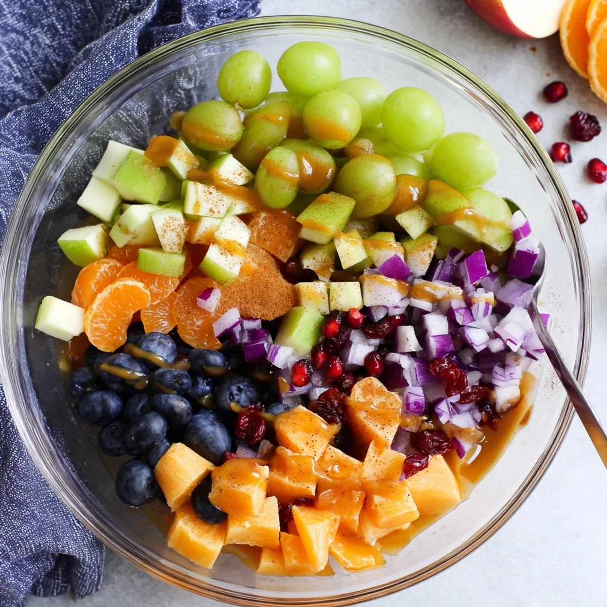 Vibrant bowl of Halloween fruit salad with pomegranate seeds and tangy honey orange glaze