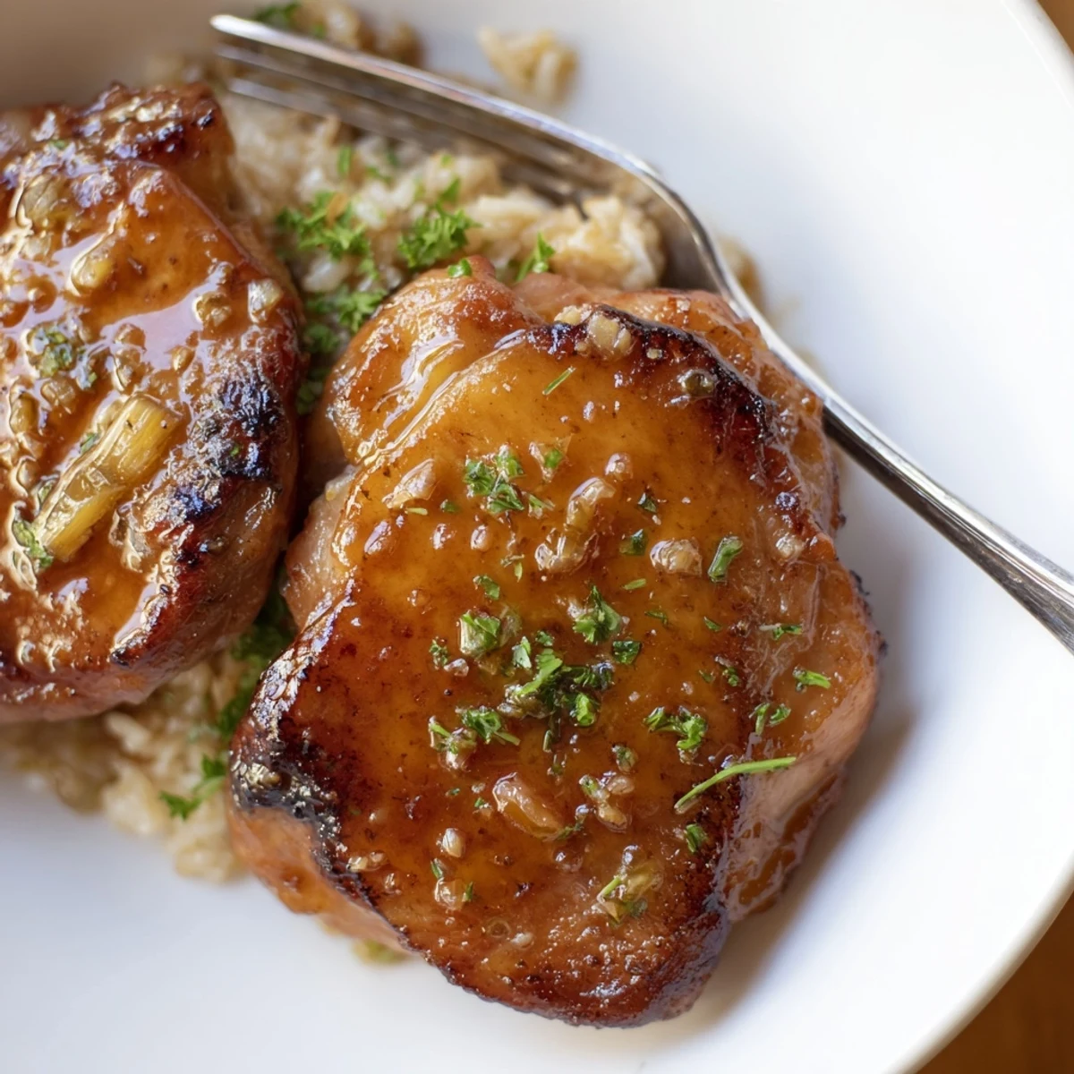 Sweet And Sticky Honey Butter Chicken Thighs glazed, golden-brown, served over fluffy rice