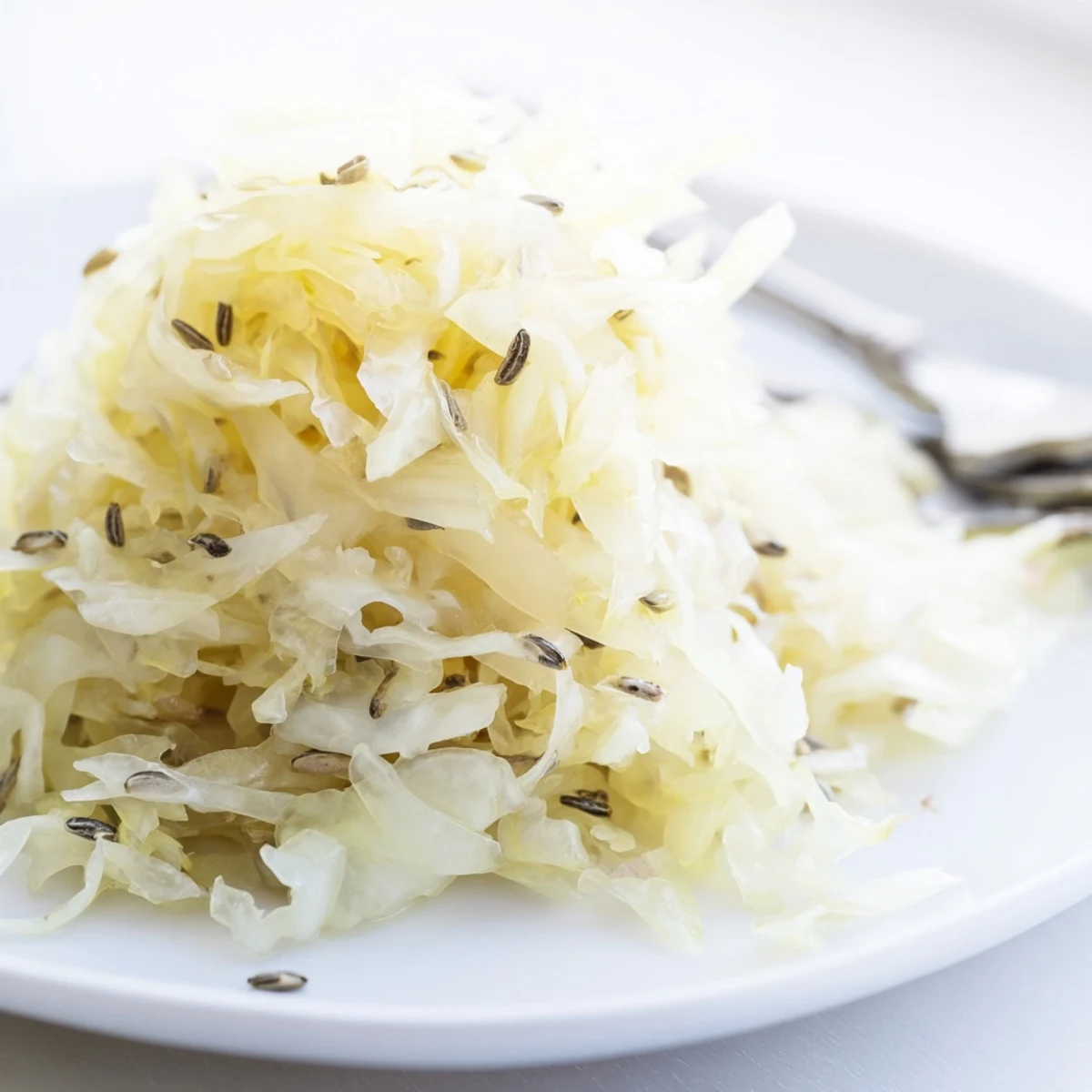 Wooden fermentation crock filled with naturally fermented sauerkraut, weights submerging cabbage beneath cloudy brine