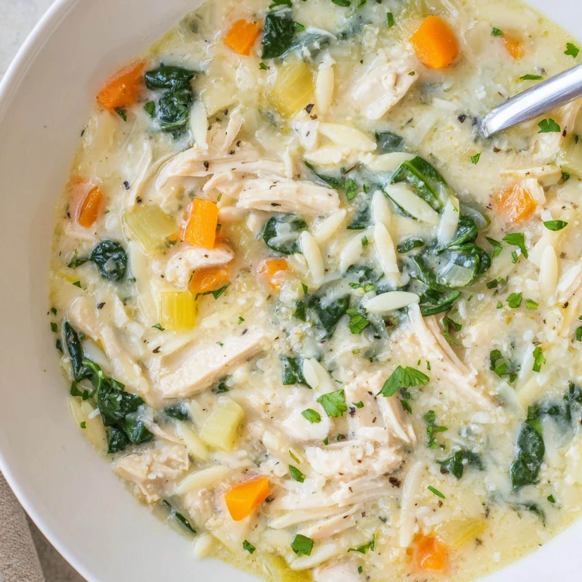 Creamy Chicken Florentine Soup With Orzo served steaming in a rustic bowl