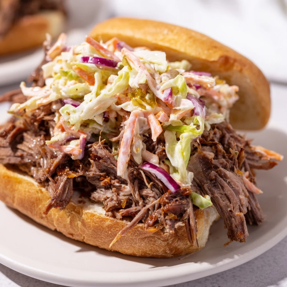 Golden smoky BBQ beef sandwiches piled on toasted buns with crunchy colorful coleslaw