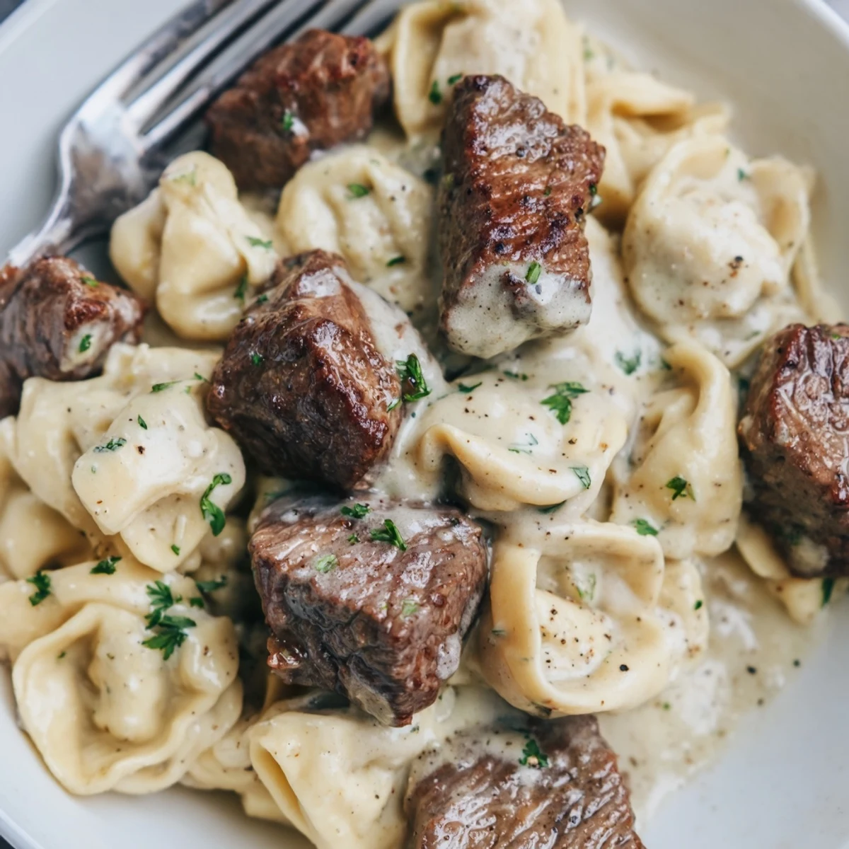 Savory steak and cheese tortellini coated in a creamy garlic parmesan sauce.
